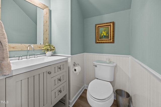 5561 Roan Mountain Pl, Raleigh, NC 27613 - half bath with wainscoting, vanity, wood finished floors, and vaulted ceiling