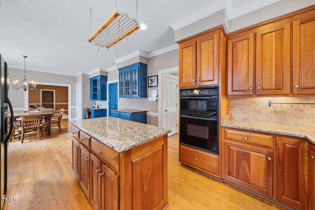 305 Lochridge Dr, Roxboro, NC 27573 - kitchen featuring a chandelier, light wood-style floors, brown cabinets, backsplash, and ornamental molding