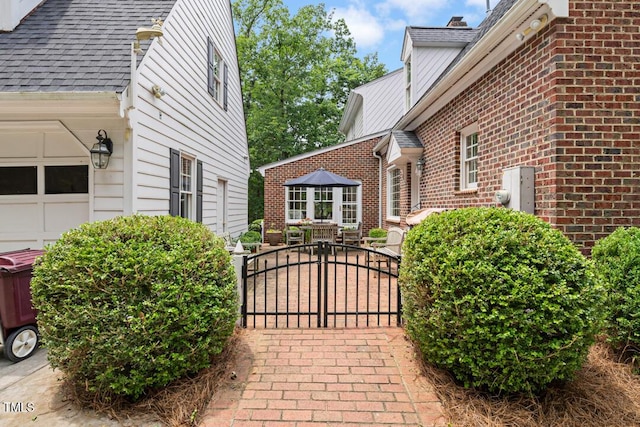 305 Lochridge Dr, Roxboro, NC 27573 - view of home's exterior with roof with shingles, a gate, and brick siding