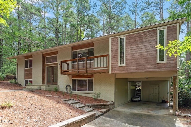 6609 Hunters Ln, Durham, NC 27713 - view of front of home featuring a carport, driveway, a balcony, and brick siding