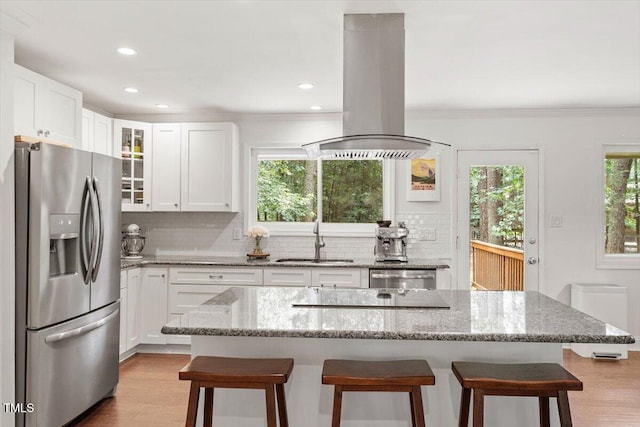 6609 Hunters Ln, Durham, NC 27713 - kitchen featuring appliances with stainless steel finishes, island exhaust hood, backsplash, healthy amount of natural light, and crown molding