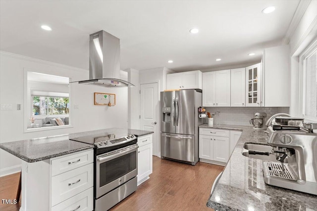 6609 Hunters Ln, Durham, NC 27713 - kitchen with appliances with stainless steel finishes, island exhaust hood, ornamental molding, stone counters, and light wood-style flooring