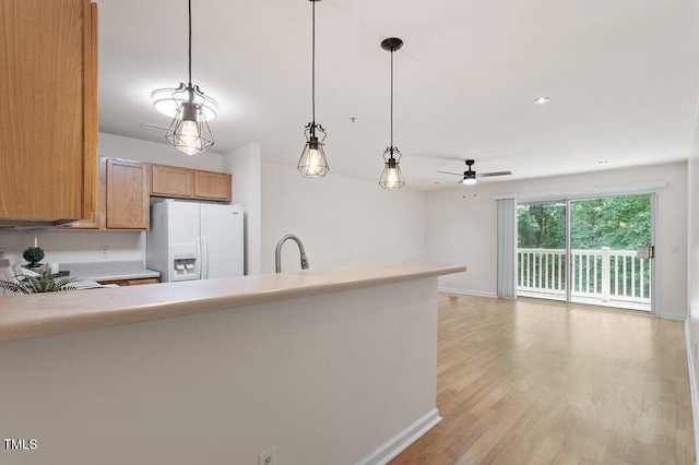 1851 Trailwood Heights Ln, Raleigh, NC 27603 - kitchen with white fridge with ice dispenser, a ceiling fan, decorative light fixtures, light countertops, and light wood-type flooring