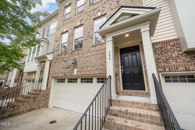 404 Panorama Park Pl, Cary, NC 27519 - doorway to property featuring a garage, brick siding, and driveway