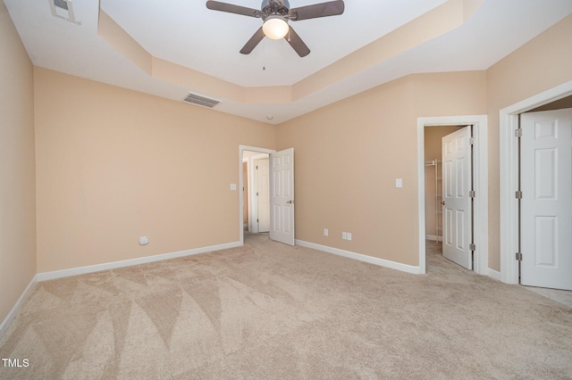 404 Panorama Park Pl, Cary, NC 27519 - unfurnished bedroom with a tray ceiling, carpet, a spacious closet, and ceiling fan