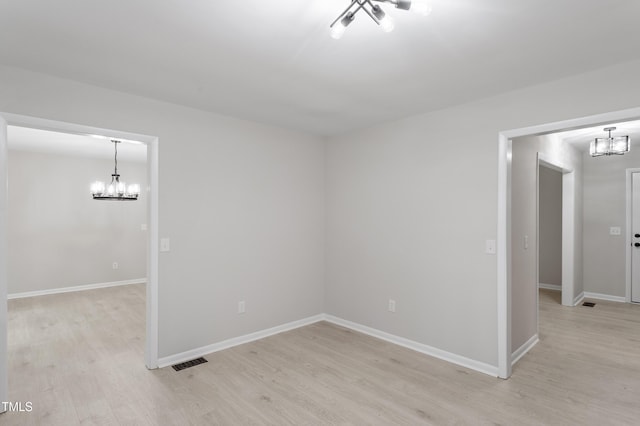 2905 Scuppernong Ln, Durham, NC 27703 - unfurnished room featuring a chandelier and light wood finished floors