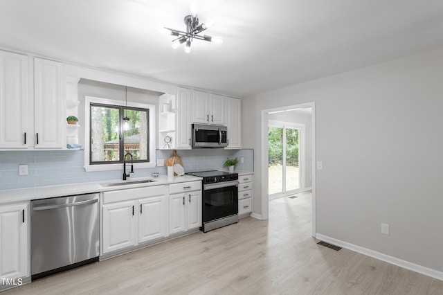 2905 Scuppernong Ln, Durham, NC 27703 - kitchen with stainless steel appliances, open shelves, tasteful backsplash, light countertops, and white cabinetry