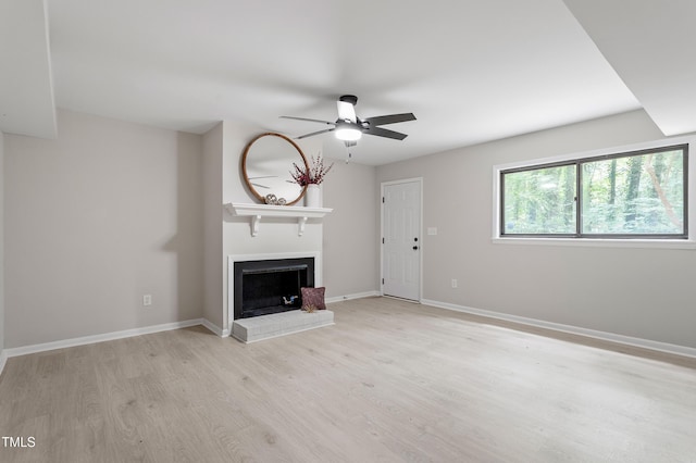 2905 Scuppernong Ln, Durham, NC 27703 - unfurnished living room featuring ceiling fan, light wood-style flooring, and a fireplace with raised hearth
