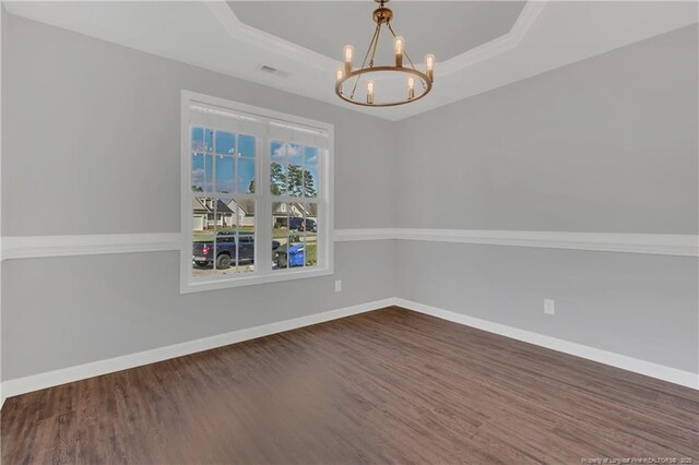 9031 Grouse Run Ln, Fayetteville, NC 28314 - unfurnished room with wood finished floors, a chandelier, a tray ceiling, baseboards, and ornamental molding