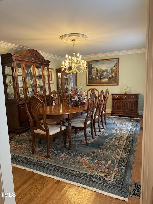 7140 N Ridge Dr, Raleigh, NC 27615 - dining area with crown molding, a chandelier, and wood finished floors