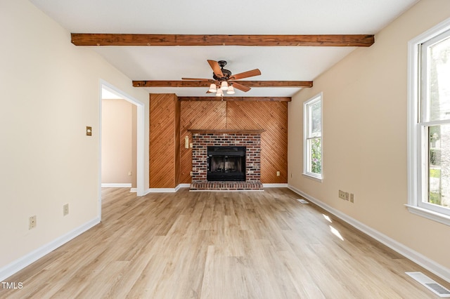 3605 Iron Sight Ct, Raleigh, NC 27616 - unfurnished living room with light wood-style floors, a fireplace, ceiling fan, beamed ceiling, and wood walls