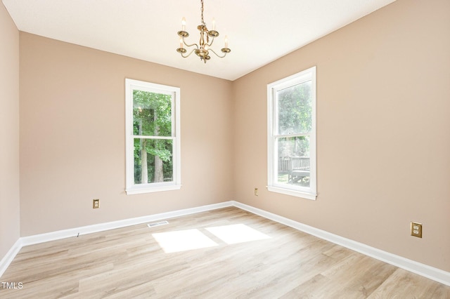 3605 Iron Sight Ct, Raleigh, NC 27616 - unfurnished room featuring a chandelier, light wood-type flooring, and healthy amount of natural light
