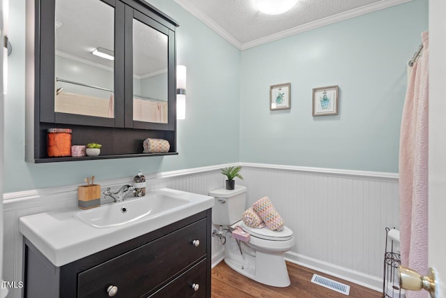 2322 Stroller Ave, Durham, NC 27705 - full bath with wainscoting, crown molding, vanity, wood finished floors, and a textured ceiling