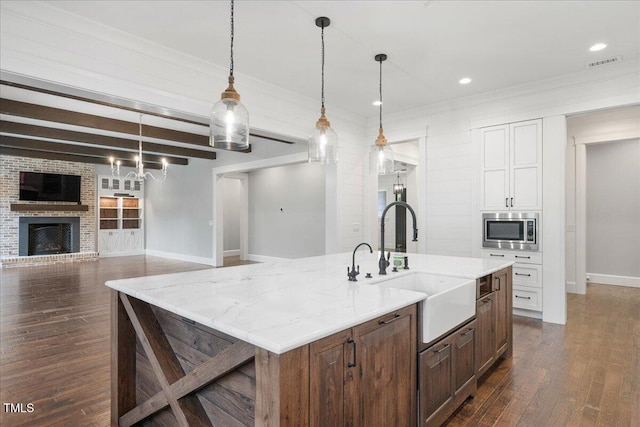 2508 Kearney Rd, Wake Forest, NC 27587 - kitchen featuring stainless steel microwave, dark wood-style flooring, a fireplace, light stone countertops, and crown molding