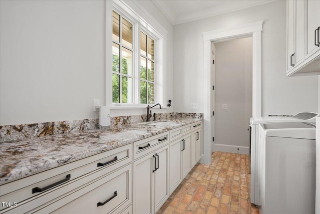 2508 Kearney Rd, Wake Forest, NC 27587 - kitchen with brick floors, independent washer and dryer, crown molding, white cabinetry, and light stone counters