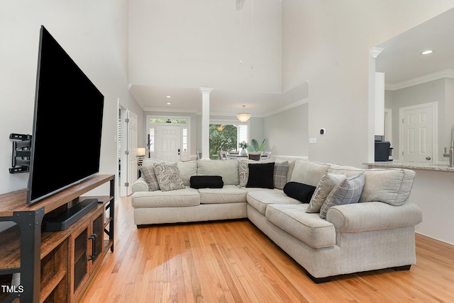 6313 Belle Crest Dr, Raleigh, NC 27612 - living area with light wood-style floors, crown molding, decorative columns, a high ceiling, and recessed lighting