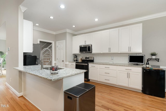 6313 Belle Crest Dr, Raleigh, NC 27612 - kitchen featuring appliances with stainless steel finishes, light wood-style flooring, white cabinetry, crown molding, and recessed lighting