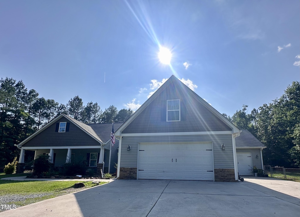 450 Rustic Ln, Sanford, NC 27330 - craftsman-style house with stone siding, driveway, an attached garage, and a porch