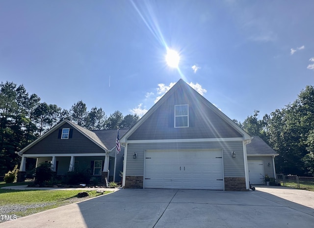 450 Rustic Ln, Sanford, NC 27330 - craftsman-style house with stone siding, driveway, an attached garage, and a porch