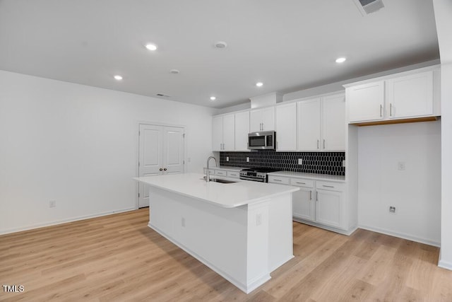 1061 Hardin Hill Ln, Knightdale, NC 27545 - kitchen with stainless steel appliances, an island with sink, white cabinetry, backsplash, and recessed lighting