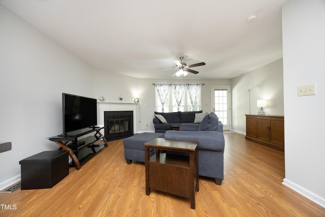 146 Greenmont Ln, Cary, NC 27511 - living area with light wood-type flooring, a ceiling fan, and a glass covered fireplace
