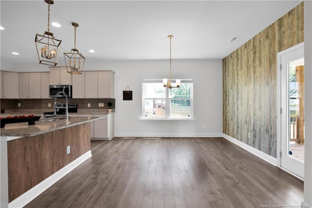 66 S Hawks Ridge Ln, Smithfield, NC 27577 - kitchen featuring appliances with stainless steel finishes, a chandelier, light stone counters, tasteful backsplash, and recessed lighting