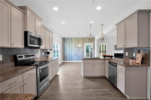66 S Hawks Ridge Ln, Smithfield, NC 27577 - kitchen featuring appliances with stainless steel finishes, wallpapered walls, baseboards, a sink, and a peninsula