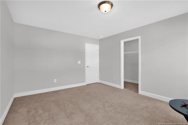 66 S Hawks Ridge Ln, Smithfield, NC 27577 - unfurnished bedroom featuring carpet, baseboards, a walk in closet, and a closet