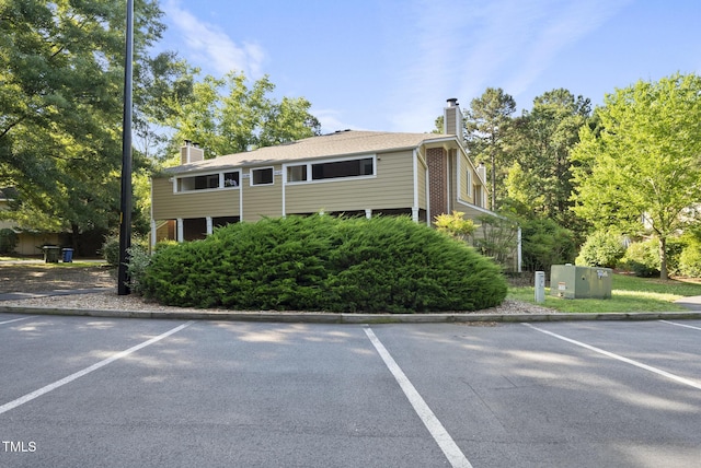 3427 Mill Run, Raleigh, NC 27612 - view of front facade featuring a chimney and uncovered parking