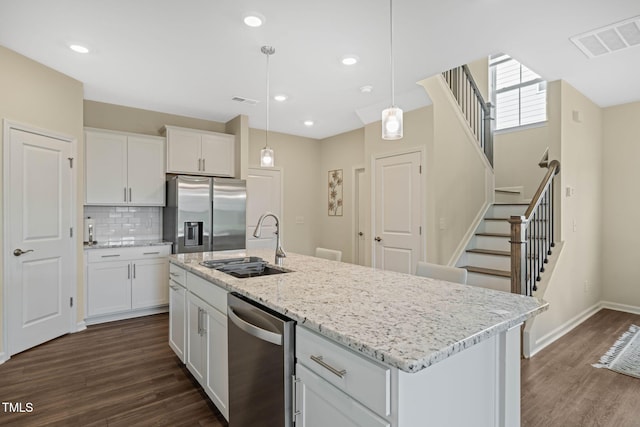 364 Abbots Mill Dr, Raleigh, NC 27603 - kitchen with stainless steel appliances, white cabinetry, dark wood-style flooring, backsplash, and pendant lighting