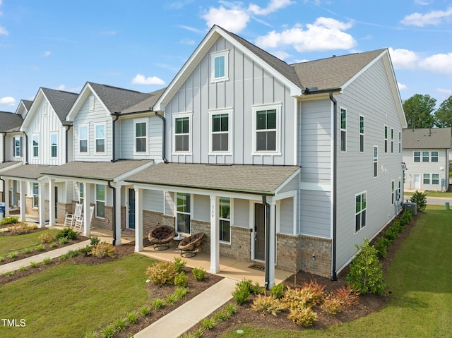 364 Abbots Mill Dr, Raleigh, NC 27603 - multi unit property featuring board and batten siding, a front lawn, brick siding, roof with shingles, and covered porch