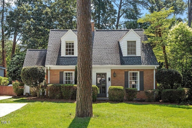 1100 Brooks Ave, Raleigh, NC 27607 - new england style home featuring brick siding, a chimney, a front lawn, and roof with shingles