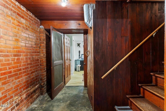 1100 Brooks Ave, Raleigh, NC 27607 - staircase with unfinished concrete flooring, brick wall, and wooden ceiling