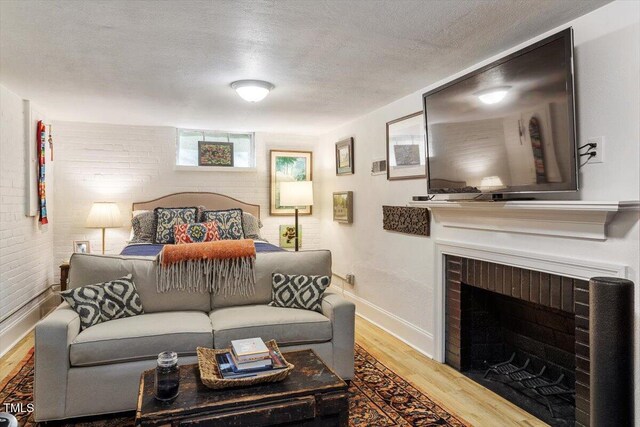 1100 Brooks Ave, Raleigh, NC 27607 - bedroom featuring wood finished floors, a fireplace, and a textured ceiling