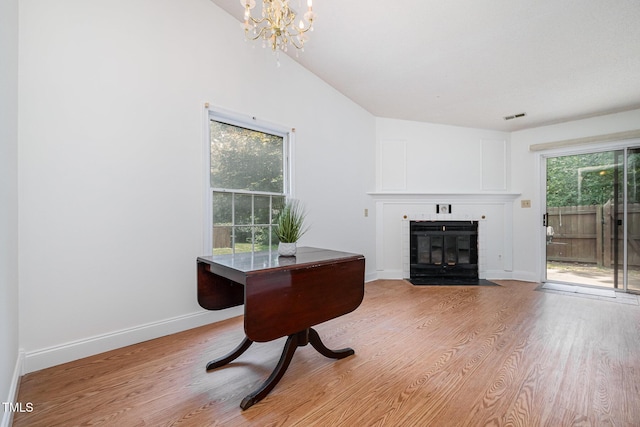 2213 Alpine Rd, Durham, NC 27707 - living room featuring a fireplace with flush hearth, light wood-style flooring, and a chandelier