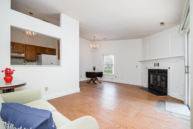 2213 Alpine Rd, Durham, NC 27707 - living area featuring a chandelier, light wood-style floors, and a fireplace with flush hearth