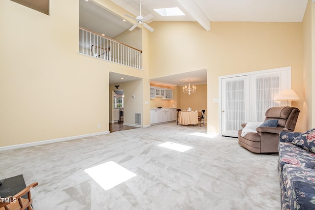 384 Lyndfield Cl W, Pittsboro, NC 27312 - living area featuring light colored carpet, a skylight, a chandelier, high vaulted ceiling, and beam ceiling