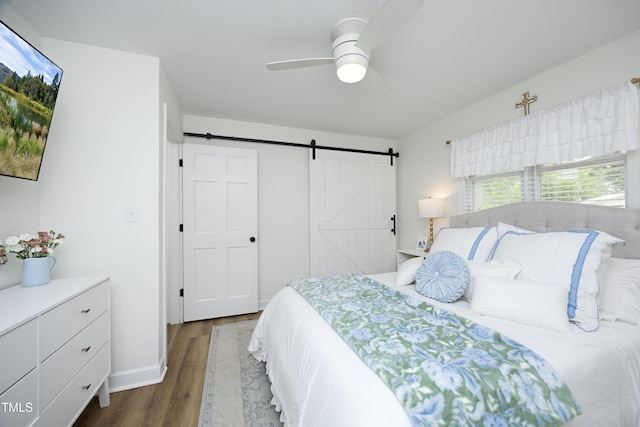 2320 Marks Creek Rd, Knightdale, NC 27545 - bedroom with wood finished floors, a barn door, and a ceiling fan