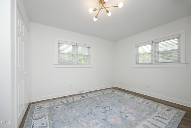 2320 Marks Creek Rd, Knightdale, NC 27545 - unfurnished bedroom featuring a chandelier, multiple windows, dark wood-style floors, and a closet