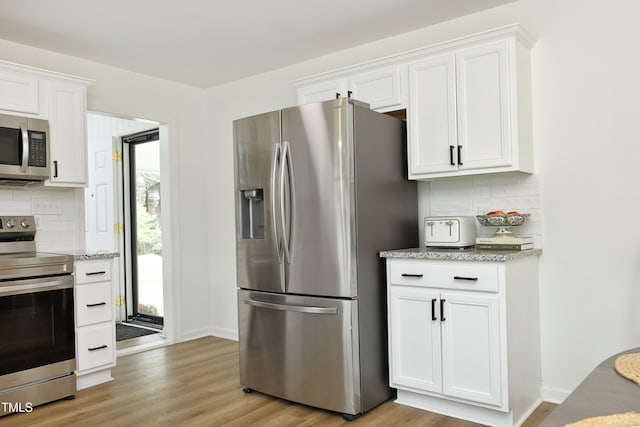 2320 Marks Creek Rd, Knightdale, NC 27545 - kitchen featuring stainless steel appliances, backsplash, white cabinetry, light wood-style floors, and light stone countertops
