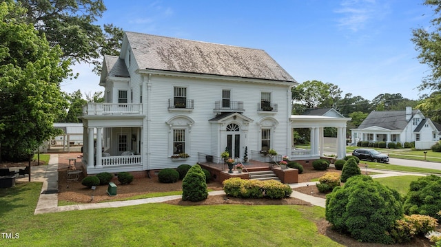 309 W Divine St, Dunn, NC 28334 - view of front of home with a balcony, a front lawn, roof with shingles, and french doors