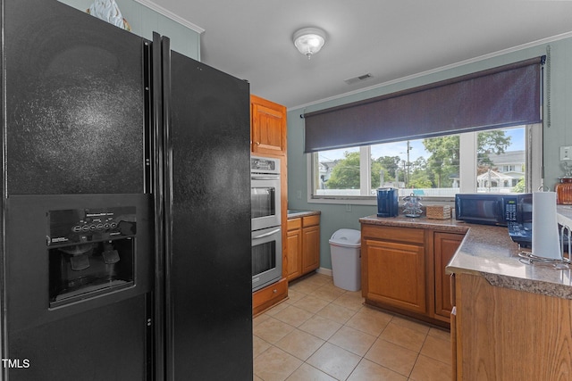 309 W Divine St, Dunn, NC 28334 - kitchen with black appliances, light tile patterned floors, brown cabinetry, and ornamental molding