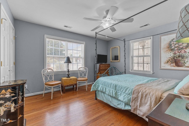 309 W Divine St, Dunn, NC 28334 - bedroom featuring wood finished floors, multiple windows, and ceiling fan