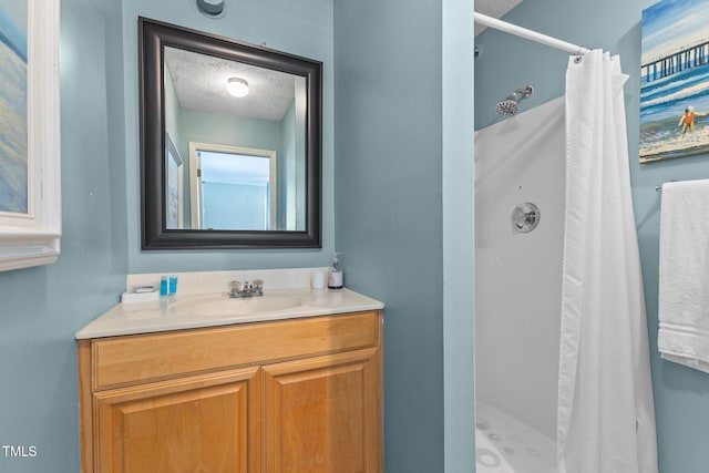 309 W Divine St, Dunn, NC 28334 - bathroom featuring a shower stall, vanity, and a textured ceiling
