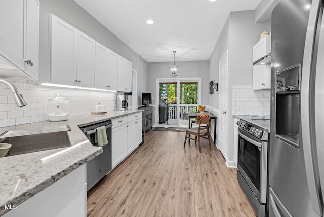 200 Holly Branch Dr, Holly Springs, NC 27540 - kitchen featuring stainless steel appliances, white cabinets, light wood-style floors, tasteful backsplash, and light stone countertops