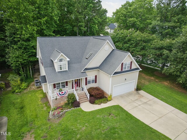 200 Holly Branch Dr, Holly Springs, NC 27540 - view of front facade with covered porch, concrete driveway, a front lawn, and a shingled roof