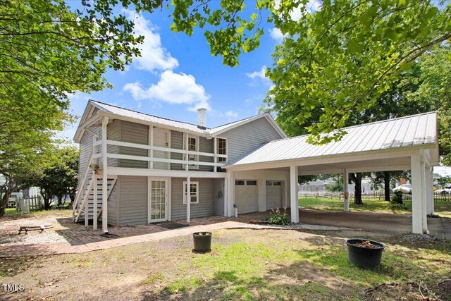 125 W Pine St, Pine Level, NC 27568 - back of property featuring an attached garage, a carport, metal roof, stairway, and driveway