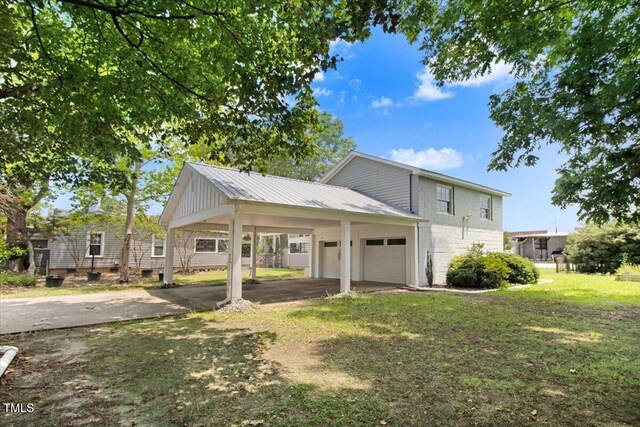 125 W Pine St, Pine Level, NC 27568 - view of front of home with concrete driveway, a front yard, a garage, and metal roof
