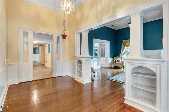 125 W Pine St, Pine Level, NC 27568 - foyer entrance with wood finished floors, ornate columns, a wainscoted wall, a chandelier, and ornamental molding