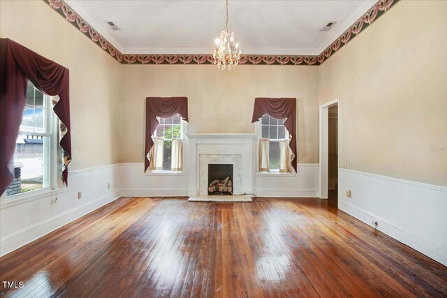 125 W Pine St, Pine Level, NC 27568 - unfurnished living room featuring healthy amount of natural light, a chandelier, hardwood / wood-style flooring, ornamental molding, and a premium fireplace